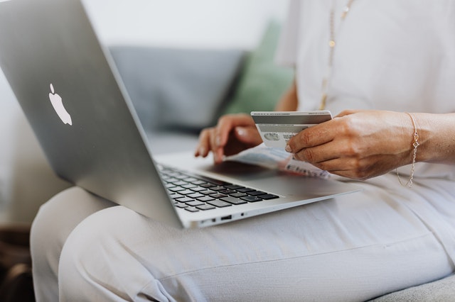 a tenant holding a credit card and laptop for an online rent payment